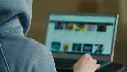 Computer screen view over shoulder unknown unrecognizable man back businessman engineer programmer hacker specialist search information online internet browser choose film tv movie on website laptop