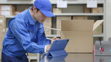 Poster - 荷物を検品してタブレットPCでチェックする男性
