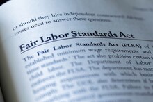 Legal Or Law Book With Fair Labor Standards Act Or FLSA Focused In Closeup Of Explanation 