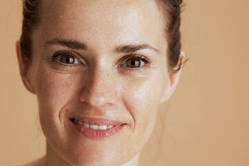 smiling modern woman with wet face washing isolated on beige