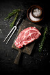© Artem Shadrin - Raw pork steak on a cutting board with spices and rosemary.