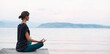 © kite_rin - Beautiful woman practicing yoga near the sea panoramic banner, Young girl meditate at sunset, Harmony, meditation, healthy lifestyle and travel concept
