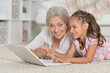 © aletia2011 - happy grandmother and granddaughter using laptop