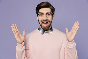 Young surprised fun excited astonished caucasian IT man he wear casual clothes pink sweater glasses look camera spread hands say wow isolated on plain pastel light purple background studio portrait.