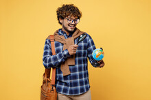 Young Smiling Teen Indian Boy IT Student He Wear Casual Clothes Glasses Bag Hold Globe Earth Map Use Magnifying Glass Isolated On Plain Yellow Color Background High School University College Concept.