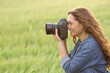 © Antonioguillem - Woman taking photos in a field