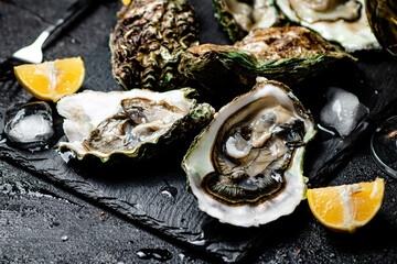 Canvas Print - Raw oysters on a stone board. 