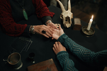 Wall Mural - Top view fortune teller and client hands over table with spiritual attributes