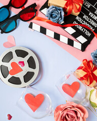 Wall Mural - beautiful composition with hearts, movie clapperboard, valentines day style gifts on blue and pink background. movie night concept. love date for two. copy space. flat lay. top view.