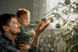 © Westend61 - Happy father and son decorating Christmas tree at home
