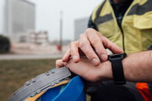 Blue-collar Worker Checking Time At Construction Site