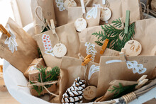 Decorated Brown Bags With Gift Boxes And Pine Cones Kept In Basket