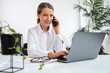 © Westend61 - Smiling businesswoman talking over mobile phone using laptop in office