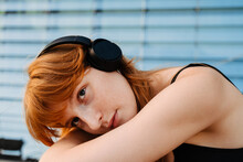 Ginger Young Woman Listening To Music With Headphones Outdoors