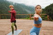 © Drobot Dean - Athletic couple doing exercises during yoga practice on terrace in mountains