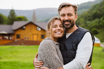 white couple smiling and hugging together while walking in forest