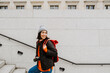 © Drobot Dean - Cheerful young asian woman climbing the stairs