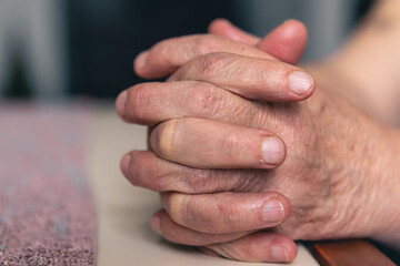 Wall Mural - Hands of an old woman folded for prayer.