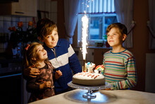 Adorable Little Toddler Girl Celebrating Third Birthday. Baby Sister Child And Two Kids Boys Brothers Blowing Together Candles On Cake. Happy Healthy Family Portrait With Three Children Siblings