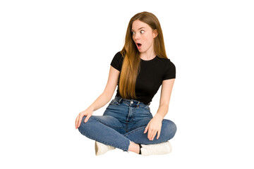 Poster - Young redhead woman sitting on the floor cut out isolated being shocked because of something she has seen.