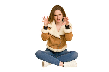 Young redhead woman sitting on the floor cut out isolated having a strong teeth pain, molar ache.