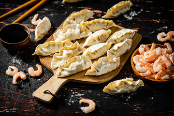 Sticker - Raw dumplings gyoza with shrimp on a cutting board. 