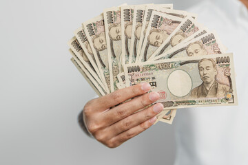 man hand holding Japanese Yen banknote stack. Thousand Yen money. Japan cash, Tax, Recession Economy, Inflation, Investment, finance and shopping payment concepts