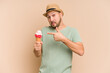 © Asier - Adult latin man eating an ice cream isolated on beige background