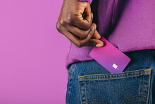 Paying With Plastic: Man Pulls A Purple Credit Card From His Pocket In A Studio