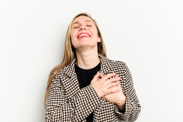 Wall Mural - Young caucasian woman isolated on white background laughing keeping hands on heart, concept of happiness.