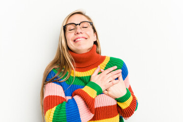 Wall Mural - Young caucasian woman isolated on white background has friendly expression, pressing palm to chest. Love concept.