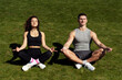 Positive couple of man and woman stretching and meditating at the lotus pose