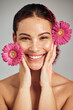 © K. A./peopleimages.com - Flowers, skincare and face portrait of a woman with natural beauty and a smile for dermatology. Facial, wellness and self care for skin glow, nature cosmetics or makeup of a healthy model in studio