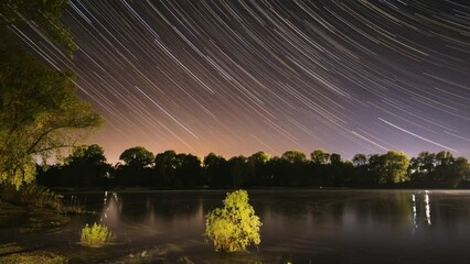 Wall Mural - 4k Timelapse Night Sky Above River. Star Lines Move In Sky. Star Trails On Night Sky Background. Amazing Starry Effects. From Dusk To Dawn. Night Sky Turns Into Morning. Dawn Is Coming. Time Lapse