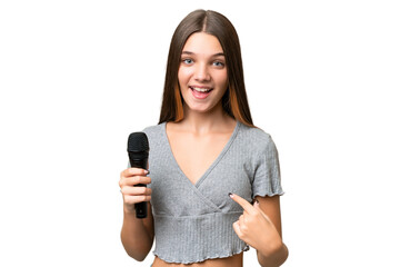 Sticker - Teenager singer girl picking up a microphone over isolated background with surprise facial expression