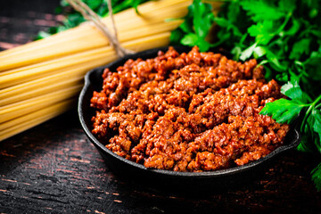 Canvas Print - Bolognese sauce with parsley and dry pasta. 