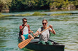 © .shock - Couple adventurous explorer friends are canoeing in a wild river surrounded by the beautiful nature
