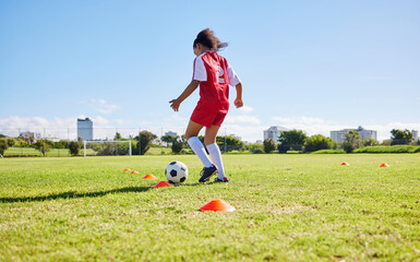 Wall Mural - Football girl child, field and training for fitness, sports and development of balance for control, speed and strong body. Female kid, fast soccer ball dribbling or workout feet on grass for learning