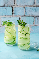 Wall Mural - Fresh infused cucumber water on a light blue background