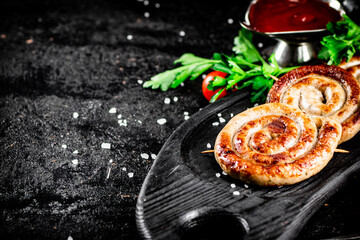 Sticker - Round grilled sausages on a tray with tomato sauce.