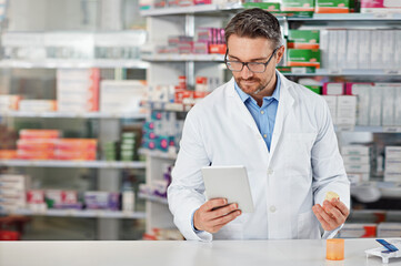 pharmacist man, shop and reading with tablet, medicine, pills and counter for health, medication or 