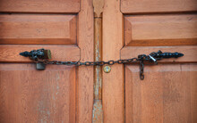 Close Up View Of A Brown Wooden Old Door And Door Handle With Chain