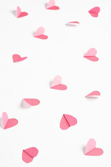 Wall Mural - Pink hearts cut out from white paper. Festive background for valentine's day.