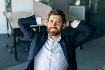 Taking break. Relaxed happy caucasian businesswoman resting on chair, leaning back at workplace in office and smiling