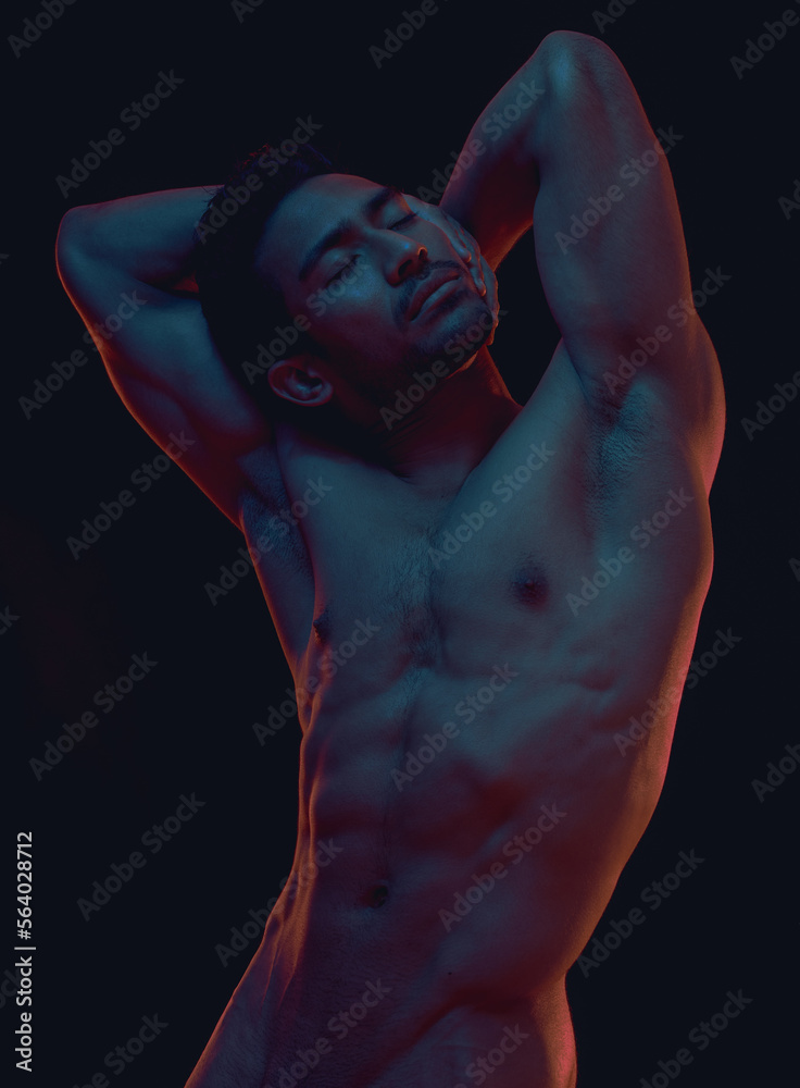 Naked, art and freedom with a model asian man in studio on a dark