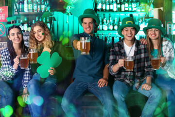 Wall Mural - Happy young friends with beer celebrating St. Patrick's Day in pub