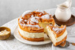 Cream puff cake Karpatka on a round table. Polish Carpathian mountain custard, sandwiche, cream cake. Consists of two layers of choux pastry with almonds and powdered sugar.