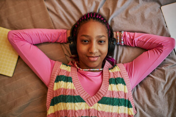 Wall Mural - Top view black teenage girl listening to music with headphones