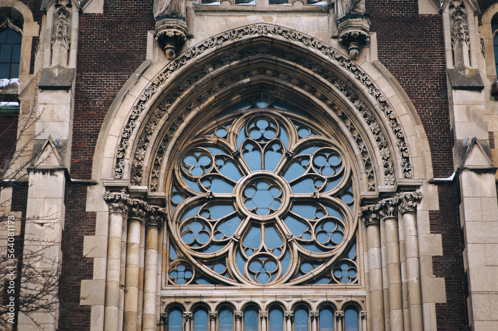 Large old openwork round window with stained glass on facade of the ...