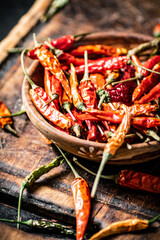 Canvas Print - Dried chili peppers in a plate on a cutting board. 